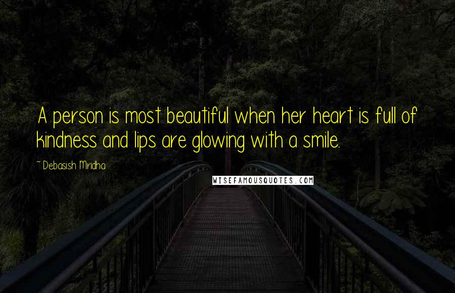 Debasish Mridha Quotes: A person is most beautiful when her heart is full of kindness and lips are glowing with a smile.