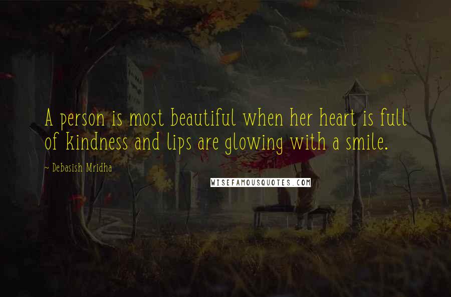 Debasish Mridha Quotes: A person is most beautiful when her heart is full of kindness and lips are glowing with a smile.