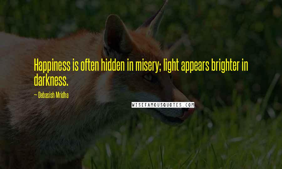 Debasish Mridha Quotes: Happiness is often hidden in misery; light appears brighter in darkness.