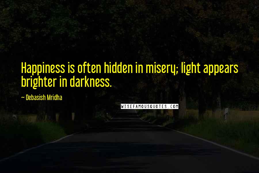 Debasish Mridha Quotes: Happiness is often hidden in misery; light appears brighter in darkness.