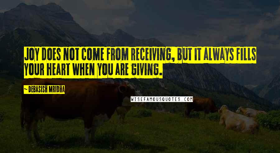 Debasish Mridha Quotes: Joy does not come from receiving, but it always fills your heart when you are giving.