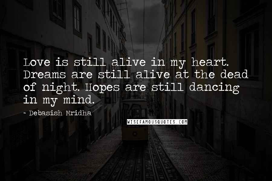 Debasish Mridha Quotes: Love is still alive in my heart. Dreams are still alive at the dead of night. Hopes are still dancing in my mind.