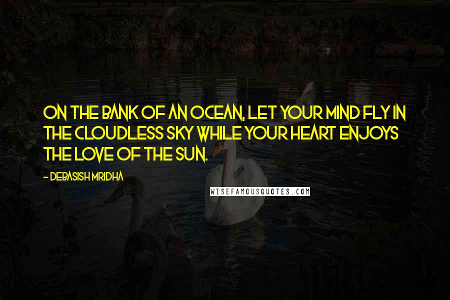 Debasish Mridha Quotes: On the bank of an ocean, let your mind fly in the cloudless sky while your heart enjoys the love of the sun.
