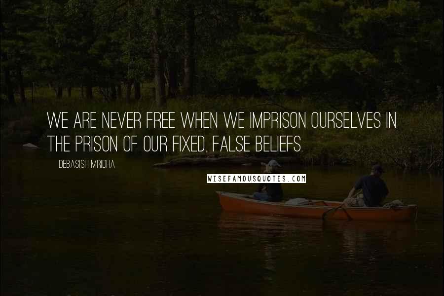 Debasish Mridha Quotes: We are never free when we imprison ourselves in the prison of our fixed, false beliefs.