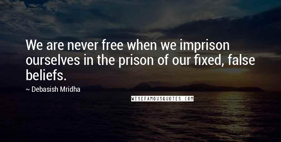 Debasish Mridha Quotes: We are never free when we imprison ourselves in the prison of our fixed, false beliefs.