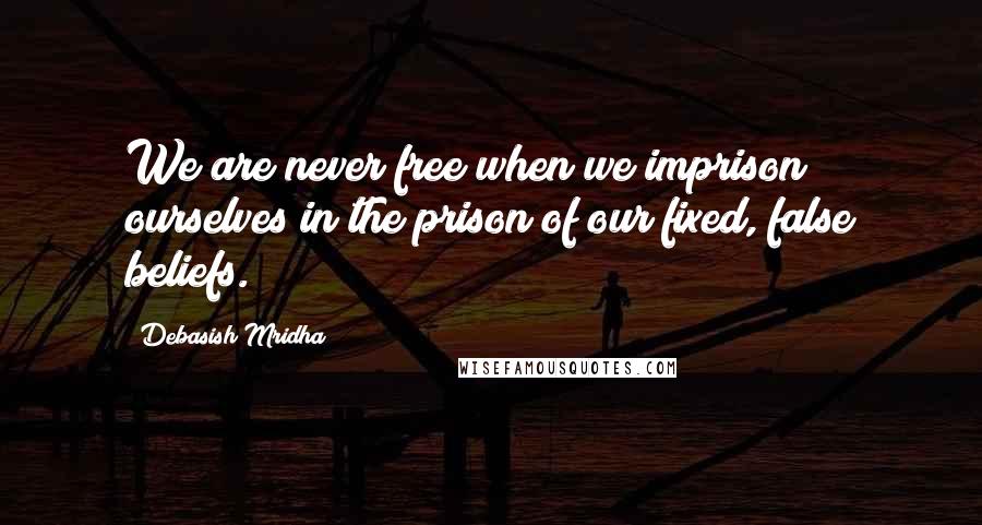 Debasish Mridha Quotes: We are never free when we imprison ourselves in the prison of our fixed, false beliefs.