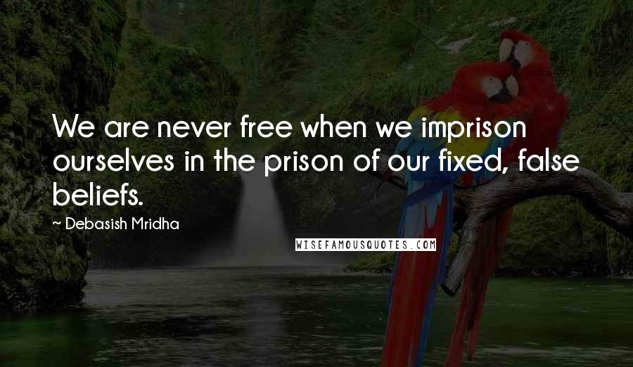 Debasish Mridha Quotes: We are never free when we imprison ourselves in the prison of our fixed, false beliefs.