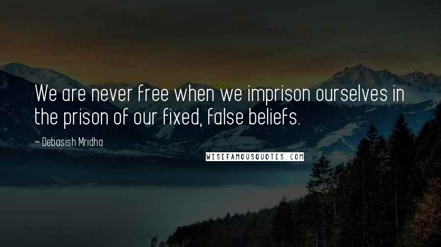 Debasish Mridha Quotes: We are never free when we imprison ourselves in the prison of our fixed, false beliefs.