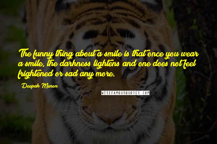 Deepak Menon Quotes: The funny thing about a smile is that once you wear a smile, the darkness lightens and one does not feel frightened or sad any more.