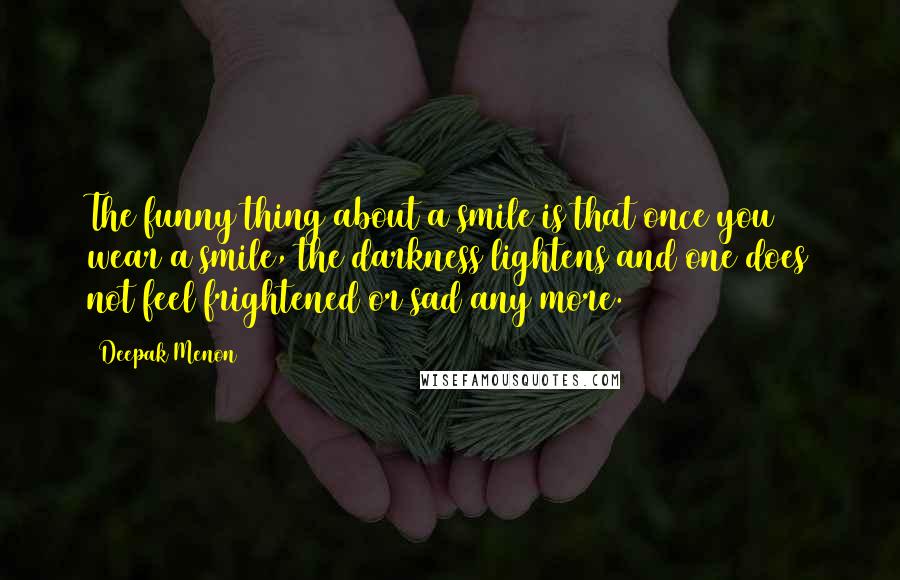 Deepak Menon Quotes: The funny thing about a smile is that once you wear a smile, the darkness lightens and one does not feel frightened or sad any more.