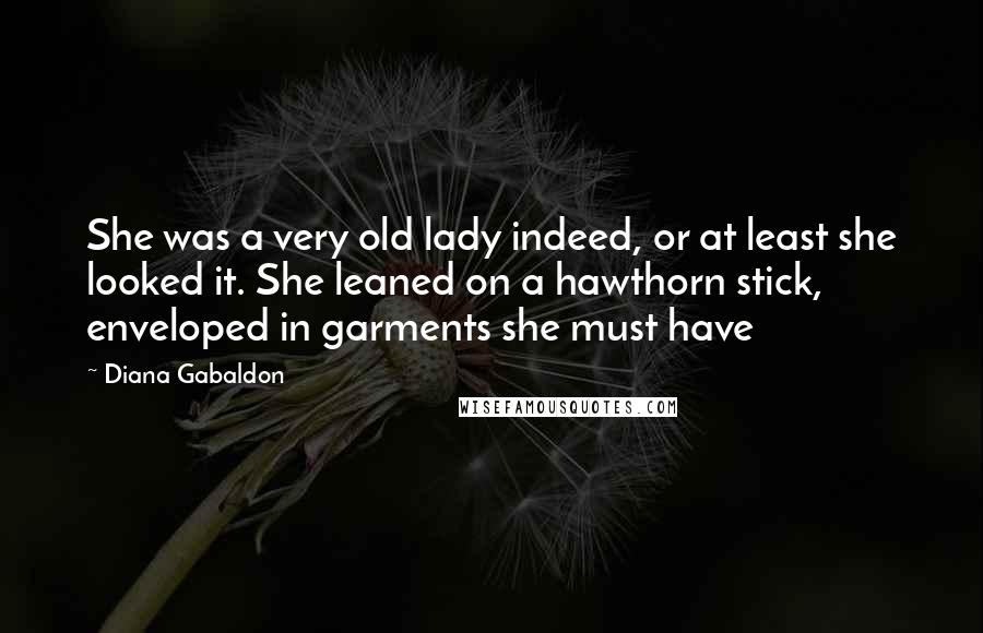 Diana Gabaldon Quotes: She was a very old lady indeed, or at least she looked it. She leaned on a hawthorn stick, enveloped in garments she must have