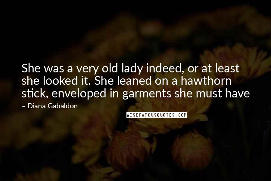Diana Gabaldon Quotes: She was a very old lady indeed, or at least she looked it. She leaned on a hawthorn stick, enveloped in garments she must have
