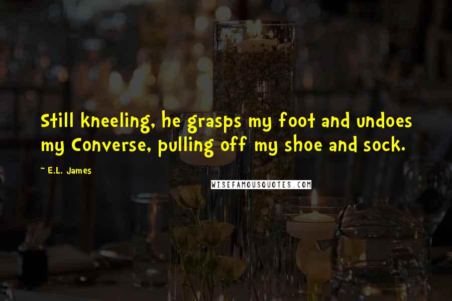 E.L. James Quotes: Still kneeling, he grasps my foot and undoes my Converse, pulling off my shoe and sock.