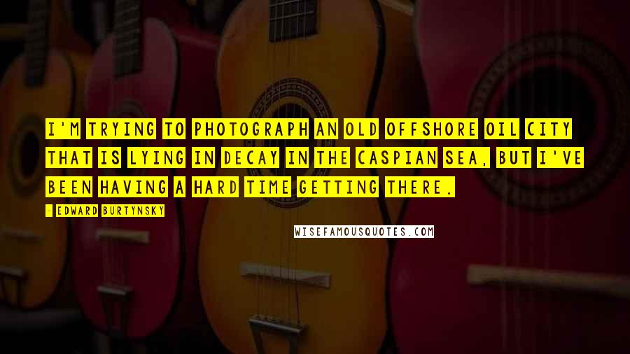 Edward Burtynsky Quotes: I'm trying to photograph an old offshore oil city that is lying in decay in the Caspian Sea, but I've been having a hard time getting there.