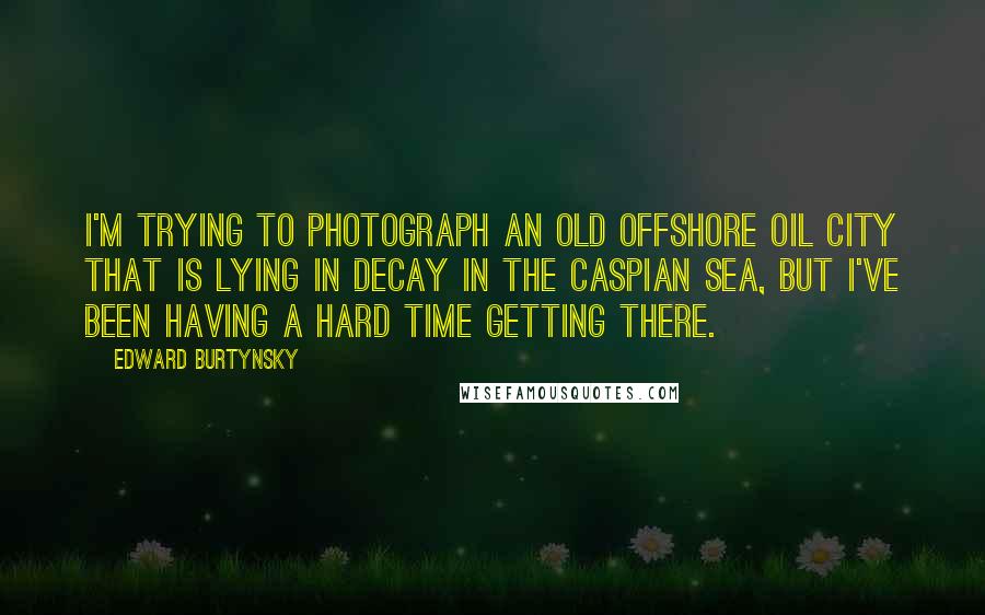 Edward Burtynsky Quotes: I'm trying to photograph an old offshore oil city that is lying in decay in the Caspian Sea, but I've been having a hard time getting there.