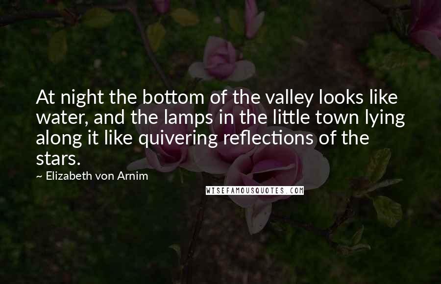 Elizabeth Von Arnim Quotes: At night the bottom of the valley looks like water, and the lamps in the little town lying along it like quivering reflections of the stars.