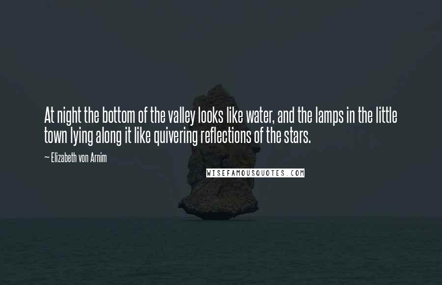 Elizabeth Von Arnim Quotes: At night the bottom of the valley looks like water, and the lamps in the little town lying along it like quivering reflections of the stars.