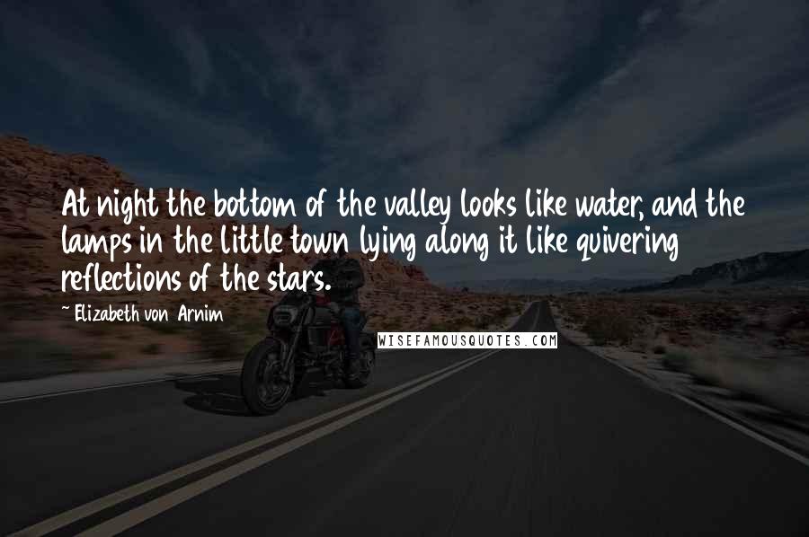 Elizabeth Von Arnim Quotes: At night the bottom of the valley looks like water, and the lamps in the little town lying along it like quivering reflections of the stars.