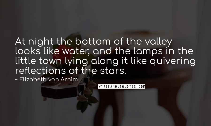 Elizabeth Von Arnim Quotes: At night the bottom of the valley looks like water, and the lamps in the little town lying along it like quivering reflections of the stars.