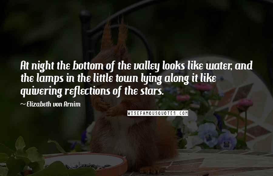 Elizabeth Von Arnim Quotes: At night the bottom of the valley looks like water, and the lamps in the little town lying along it like quivering reflections of the stars.