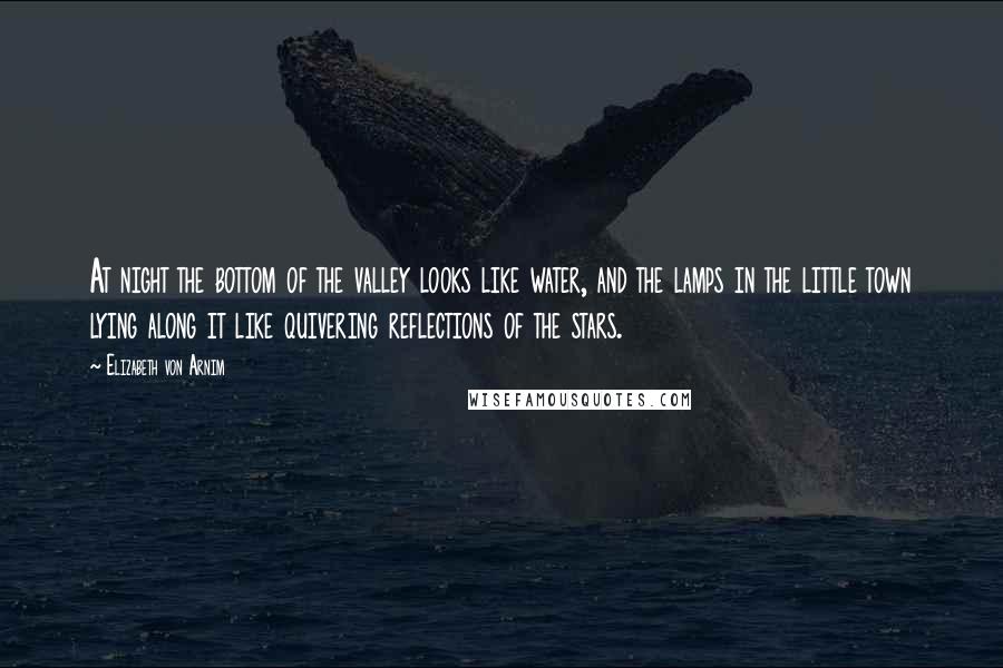 Elizabeth Von Arnim Quotes: At night the bottom of the valley looks like water, and the lamps in the little town lying along it like quivering reflections of the stars.