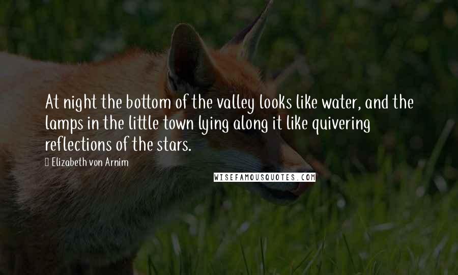 Elizabeth Von Arnim Quotes: At night the bottom of the valley looks like water, and the lamps in the little town lying along it like quivering reflections of the stars.