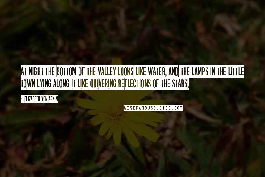 Elizabeth Von Arnim Quotes: At night the bottom of the valley looks like water, and the lamps in the little town lying along it like quivering reflections of the stars.