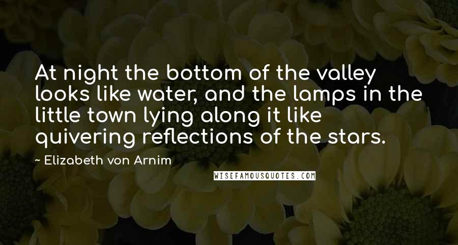 Elizabeth Von Arnim Quotes: At night the bottom of the valley looks like water, and the lamps in the little town lying along it like quivering reflections of the stars.