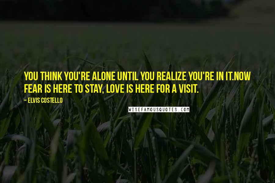 Elvis Costello Quotes: You think you're alone until you realize you're in it.Now fear is here to stay, love is here for a visit.