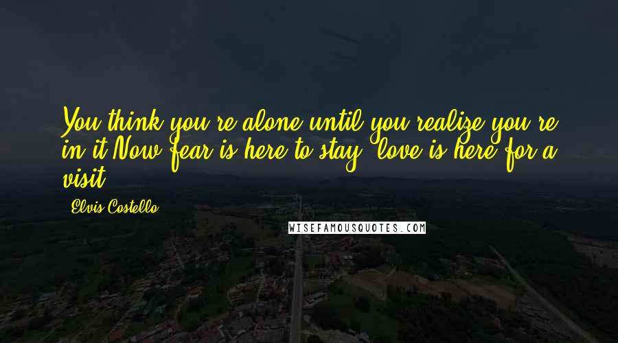 Elvis Costello Quotes: You think you're alone until you realize you're in it.Now fear is here to stay, love is here for a visit.