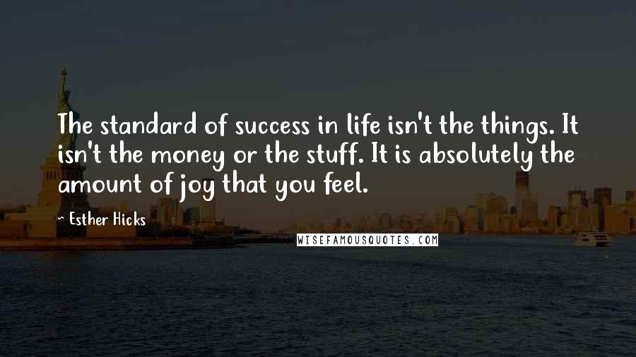 Esther Hicks Quotes: The standard of success in life isn't the things. It isn't the money or the stuff. It is absolutely the amount of joy that you feel.