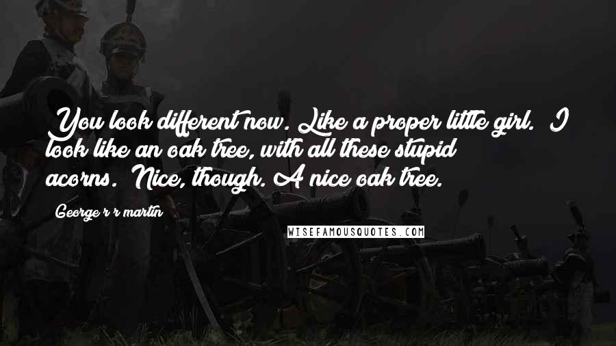 George R R Martin Quotes: You look different now. Like a proper little girl.""I look like an oak tree, with all these stupid acorns.""Nice, though. A nice oak tree.