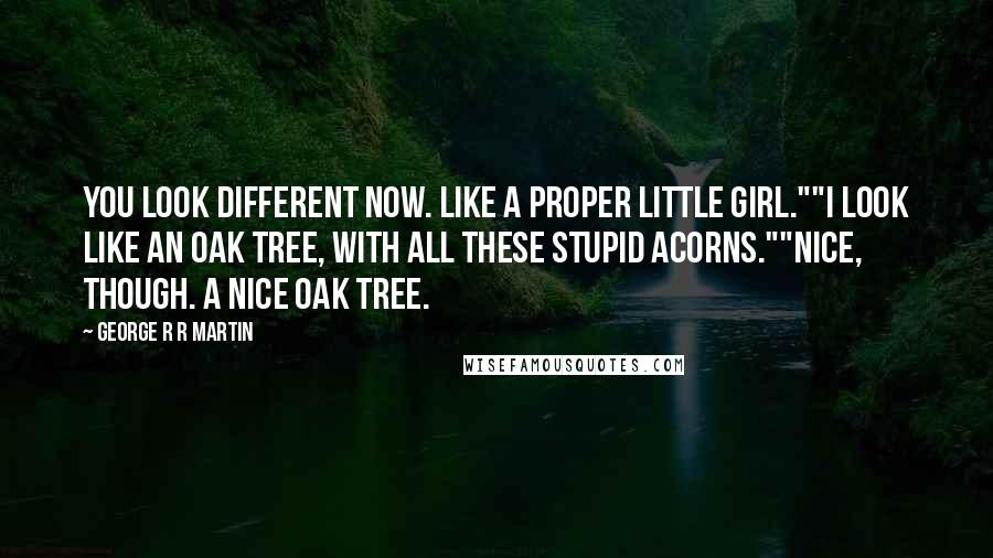 George R R Martin Quotes: You look different now. Like a proper little girl.""I look like an oak tree, with all these stupid acorns.""Nice, though. A nice oak tree.