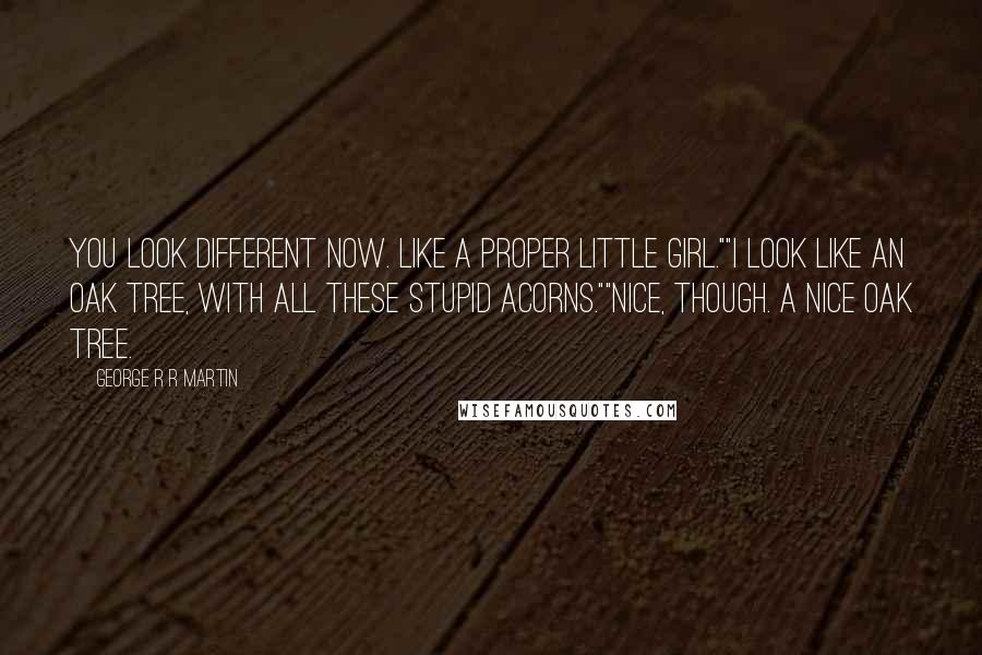 George R R Martin Quotes: You look different now. Like a proper little girl.""I look like an oak tree, with all these stupid acorns.""Nice, though. A nice oak tree.