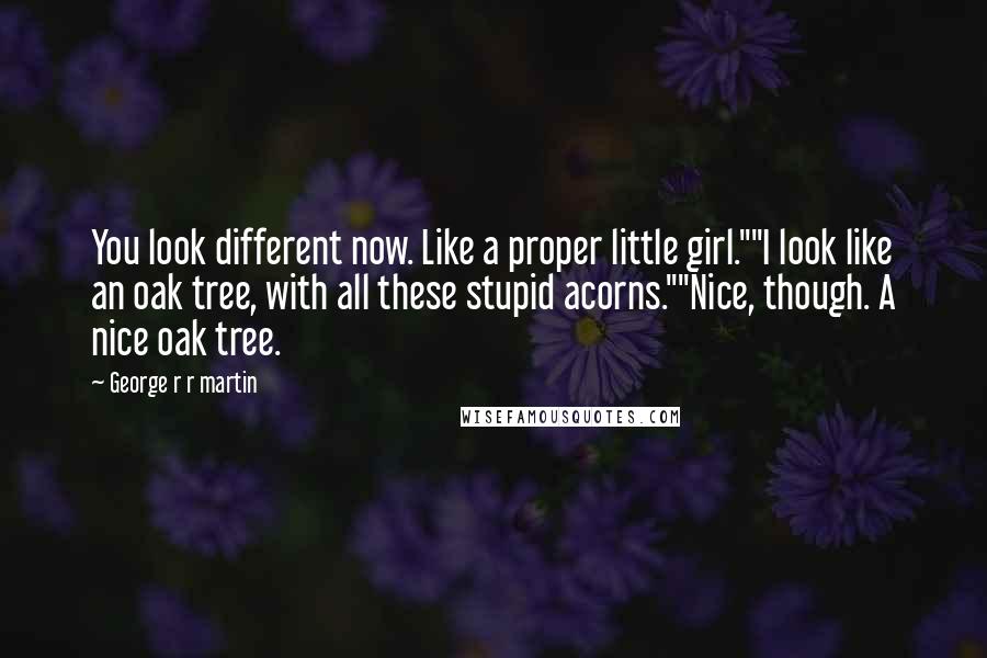 George R R Martin Quotes: You look different now. Like a proper little girl.""I look like an oak tree, with all these stupid acorns.""Nice, though. A nice oak tree.