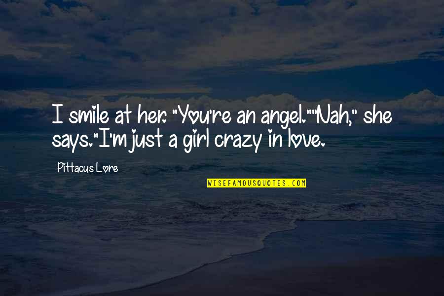 A Girl And Her Smile Quotes By Pittacus Lore: I smile at her. "You're an angel.""Nah," she
