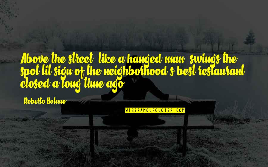 Ago's Quotes By Roberto Bolano: Above the street, like a hanged man, swings