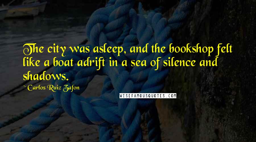 Carlos Ruiz Zafon quotes: The city was asleep, and the bookshop felt like a boat adrift in a sea of silence and shadows.