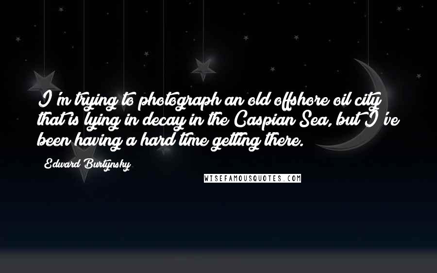 Edward Burtynsky quotes: I'm trying to photograph an old offshore oil city that is lying in decay in the Caspian Sea, but I've been having a hard time getting there.