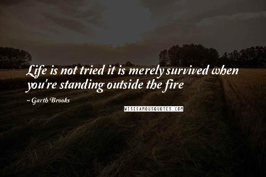 Garth Brooks quotes: Life is not tried it is merely survived when you're standing outside the fire