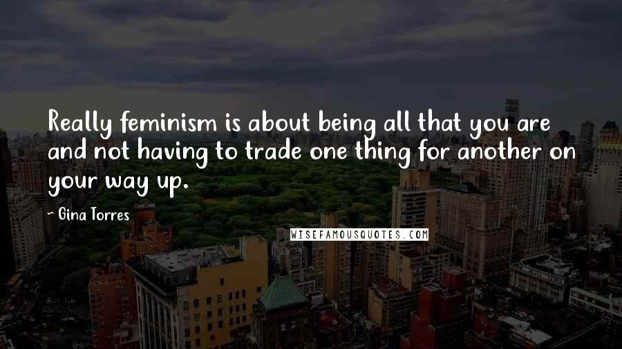 Gina Torres quotes: Really feminism is about being all that you are and not having to trade one thing for another on your way up.