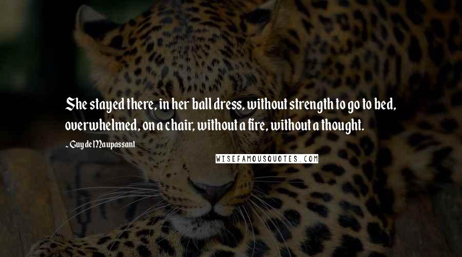 Guy De Maupassant quotes: She stayed there, in her ball dress, without strength to go to bed, overwhelmed, on a chair, without a fire, without a thought.