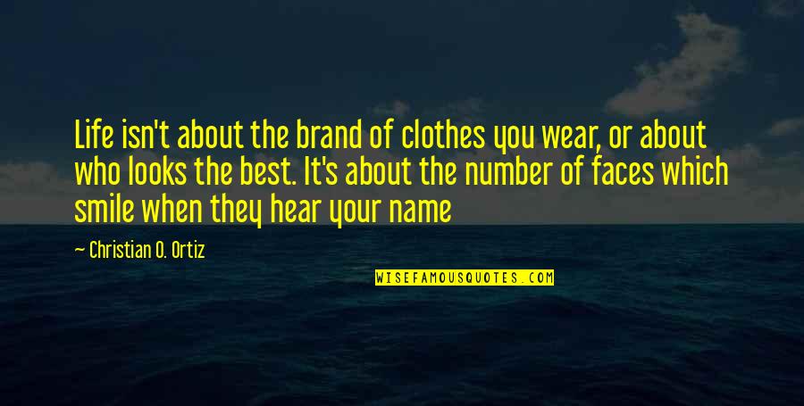 I Wear My Smile Quotes By Christian O. Ortiz: Life isn't about the brand of clothes you