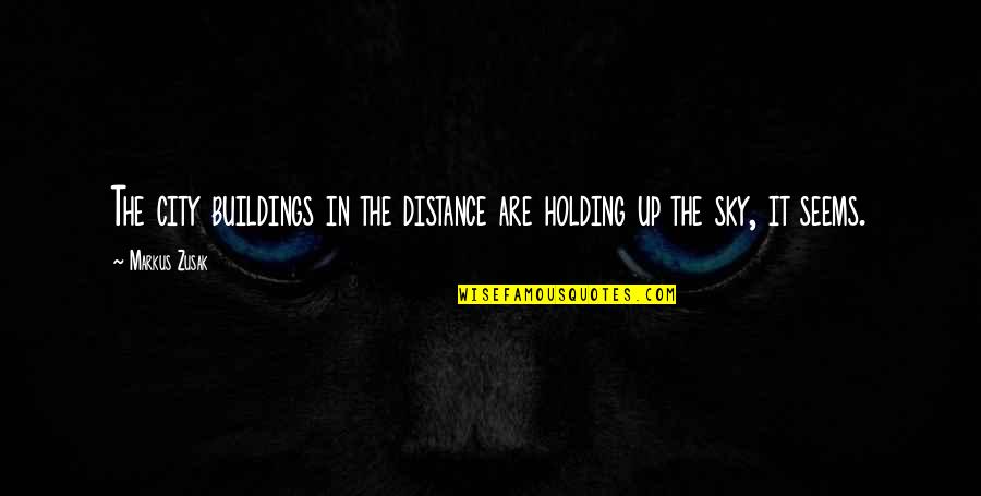 Inclinations Grandchildren Quotes By Markus Zusak: The city buildings in the distance are holding