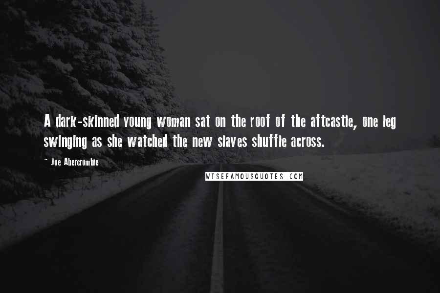 Joe Abercrombie quotes: A dark-skinned young woman sat on the roof of the aftcastle, one leg swinging as she watched the new slaves shuffle across.