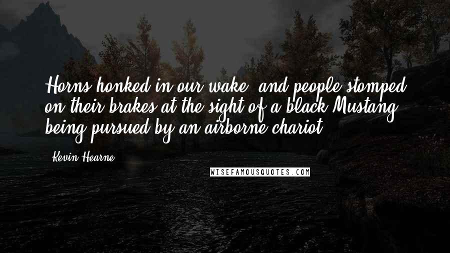 Kevin Hearne quotes: Horns honked in our wake, and people stomped on their brakes at the sight of a black Mustang being pursued by an airborne chariot.