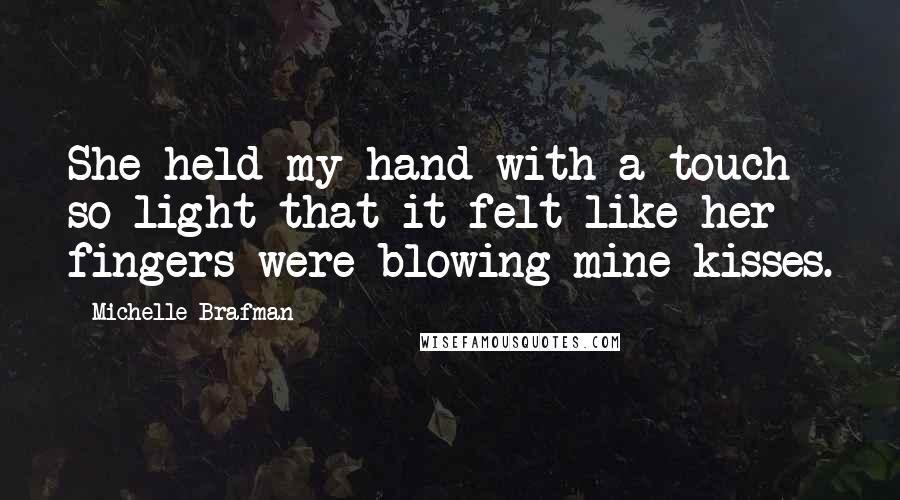 Michelle Brafman quotes: She held my hand with a touch so light that it felt like her fingers were blowing mine kisses.