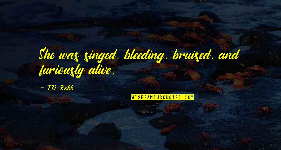 Reuther Material Quotes By J.D. Robb: She was singed, bleeding, bruised, and furiously alive.