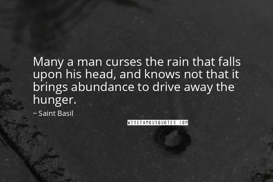Saint Basil quotes: Many a man curses the rain that falls upon his head, and knows not that it brings abundance to drive away the hunger.
