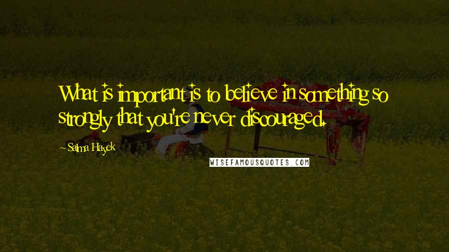 Salma Hayek quotes: What is important is to believe in something so strongly that you're never discouraged.